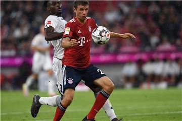 Thomas Müller (r) vom FC Bayern München im Duell mit Kasim Adams. Der Hoffenheimer fällt verletzt aus. Foto: Sven Hoppe