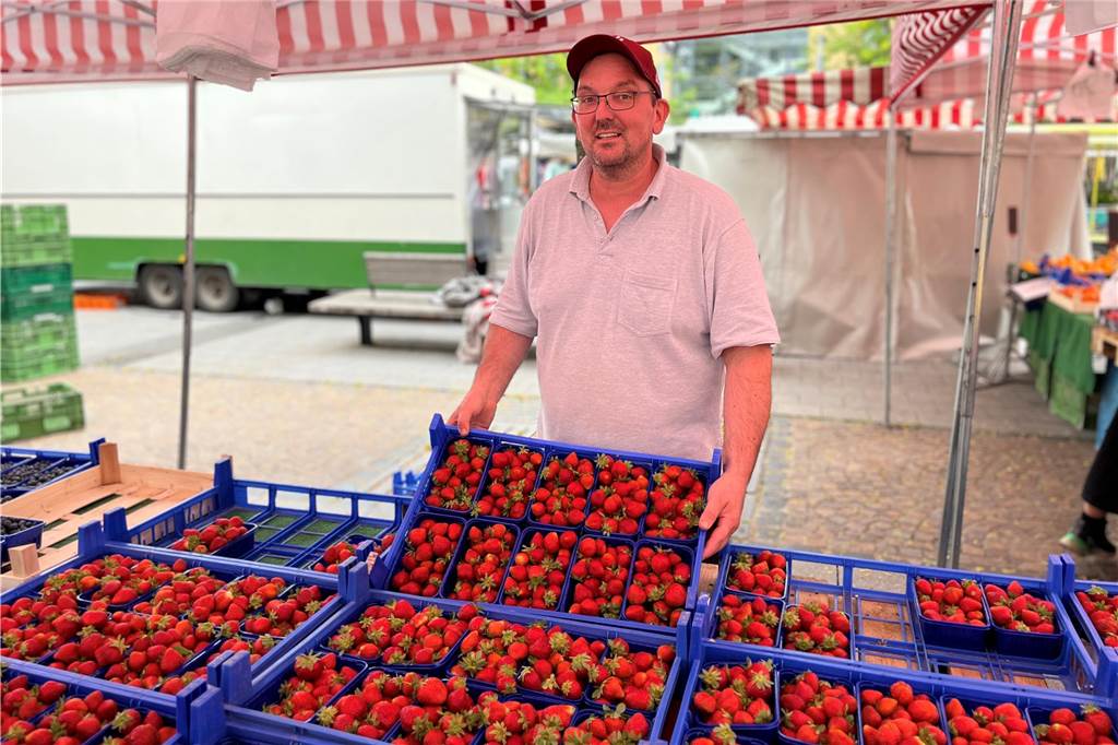 „Pfläumchen von Omas Bäumchen“: Sahin Temiz lebt für den Wochenmarkt Thomas Peters hält eine Kiste Erdbeeren in der Hand.