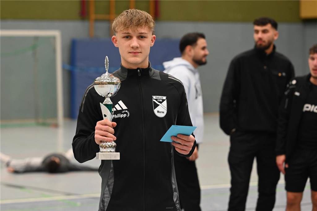 Ein später Treffer entscheidet die Stadtmeisterschaft Tim Hölscher hält einen Pokal in der Hand.