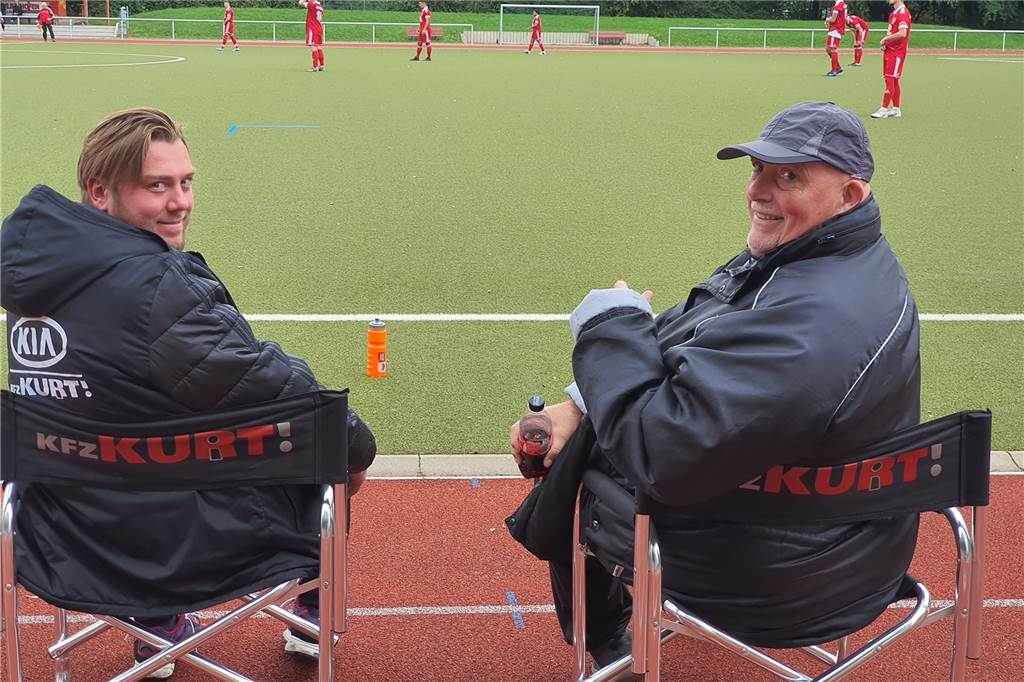Stephan Pade leistet Entwicklungshilfe für den Castrop-Rauxeler Handballsport Tino Westphal (l), der Trainer der SG Castrop, sitzt während der Spiele eigentlich auf einem "fremden" Stuhl - wenn man den aufgedruckten Namen sieht.