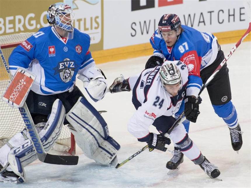 Eisbären im Achtelfinale - EHC München und Wolfsburg raus Tobias Fohrler vom EV Zug (r) bremst den Berliner Andre Rankel vor dem Tor. Foto: Urs Flueeler