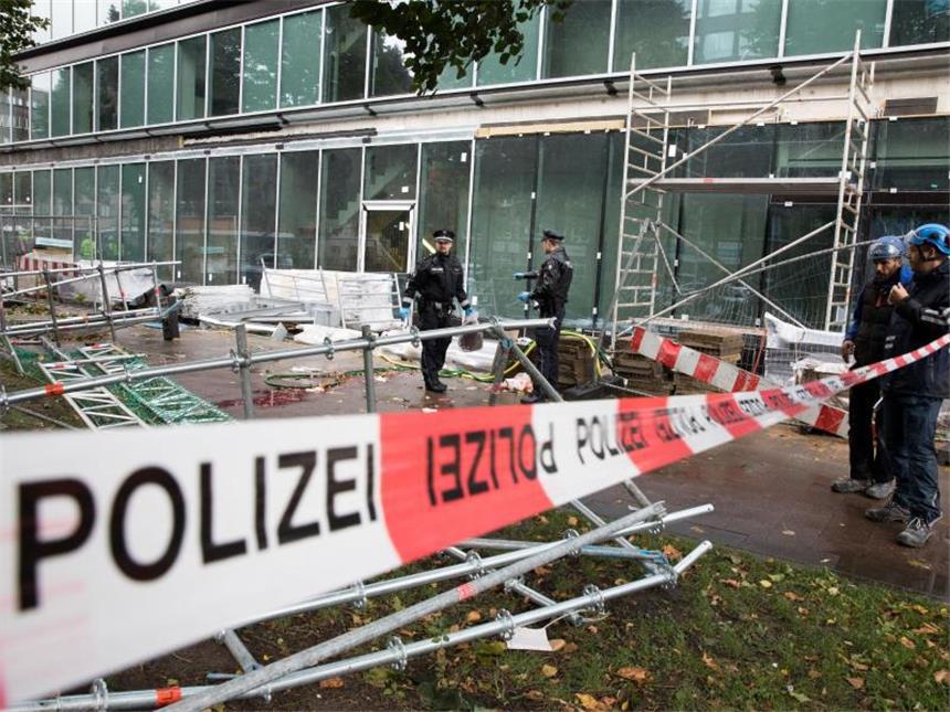 Orkantief wütet über weiten Teilen Deutschlands Tödlicher Unfall: Polizeibeamte sichern in Hamburg ein umgestürztes Baugerüst, das einen Passanten unter sich begraben und getötet hatte. Foto: Christian Charisius