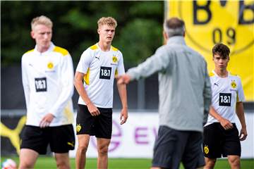 BVB-Trainer Marco Rose steht mit dem Rücken zur Kamera und erteilt den BVB-Youngstern um Tom Rothe Anweisungen.