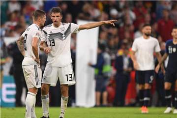 Toni Kroos (l) unterhält sich nach dem Spiel mit Thomas Müller. Foto: Marius Becker