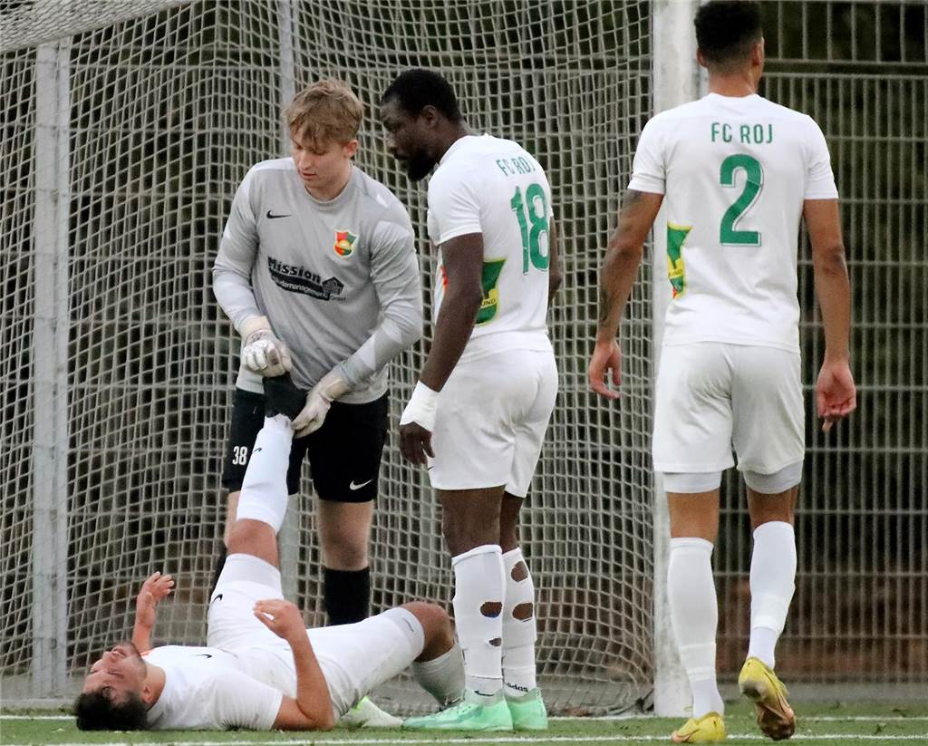 Torben Simon dehnt einem Mitspieler das Bein.
