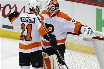 Torwart Brian Elliott (r) von den Philadelphia Flyers jubelt mit seinem Teamkollegen Scott Laughton nach dem Spiel. Foto: Gene J. Puskar/AP
