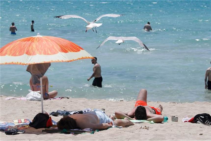 Deutsche trotz Corona am Ballermann: „Doppelt geimpft, doppelt Spaß“ Touristen genießen die Sonne am Strand von Arenal. Foto: Clara Margais/dpa