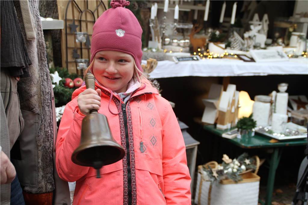 Öffnungszeiten, Nikolaus, Neuheiten: Infos zum Weihnachtsmarkt 2024 Ein Mädchen klingelt beim Weihnachtsmarkt in Südlohn mit einer Glocke.