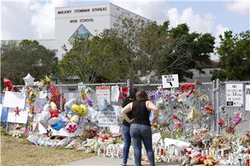 Trauernde an der Marjory Stoneman Douglas High School. Unzählige Kerzen und Blumen wurden für die Opfer des Massakers abgelegt. Foto: David Santiago