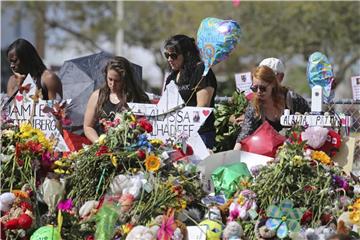 Trauernde legen an der Marjory Stoneman Douglas High School Blumen für die Opfer des Massakers nieder. Foto: David Santiago/Miami Herald/AP