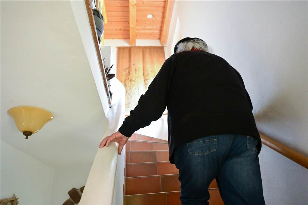 Ein älterer Mann steigt eine Treppe hinauf.