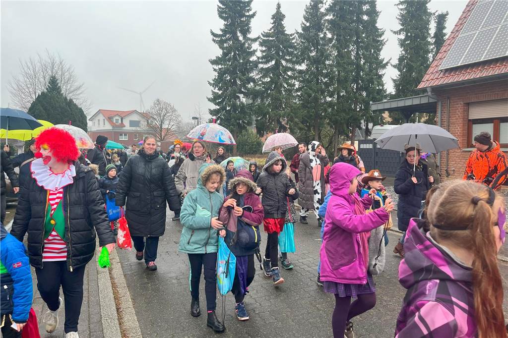 Menschen laufen durch den Regen beim Karnevalsumzug.
