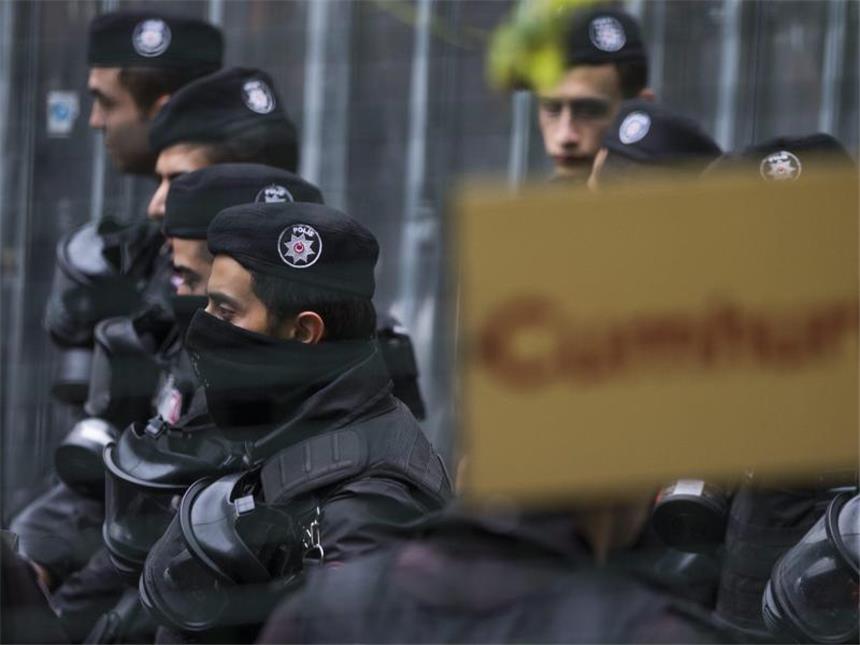 Türkei geht gegen kritische Zeitung "Cumhuriyet" vor Türkische Polizisten stehen vor der Cumhuryiet-Zentrale einer protestierenden Menge gegenüber, die gegen die Festnahme zweier Journalisten demonstriert. Foto: Tolga Bozoglu/Archiv