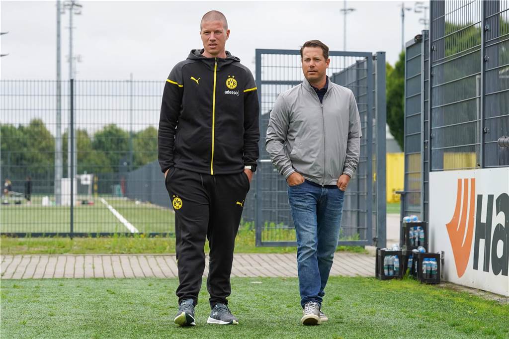 Mike Tullberg und Lars Ricken gehen über den Rasen.