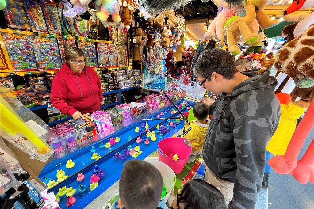 Stadtverwaltung zeigt nach Haushaltsdebatte mehrere Sparpotentiale auf Eine Familie an einer Bude auf der Maikirmes in Werne 2024.
