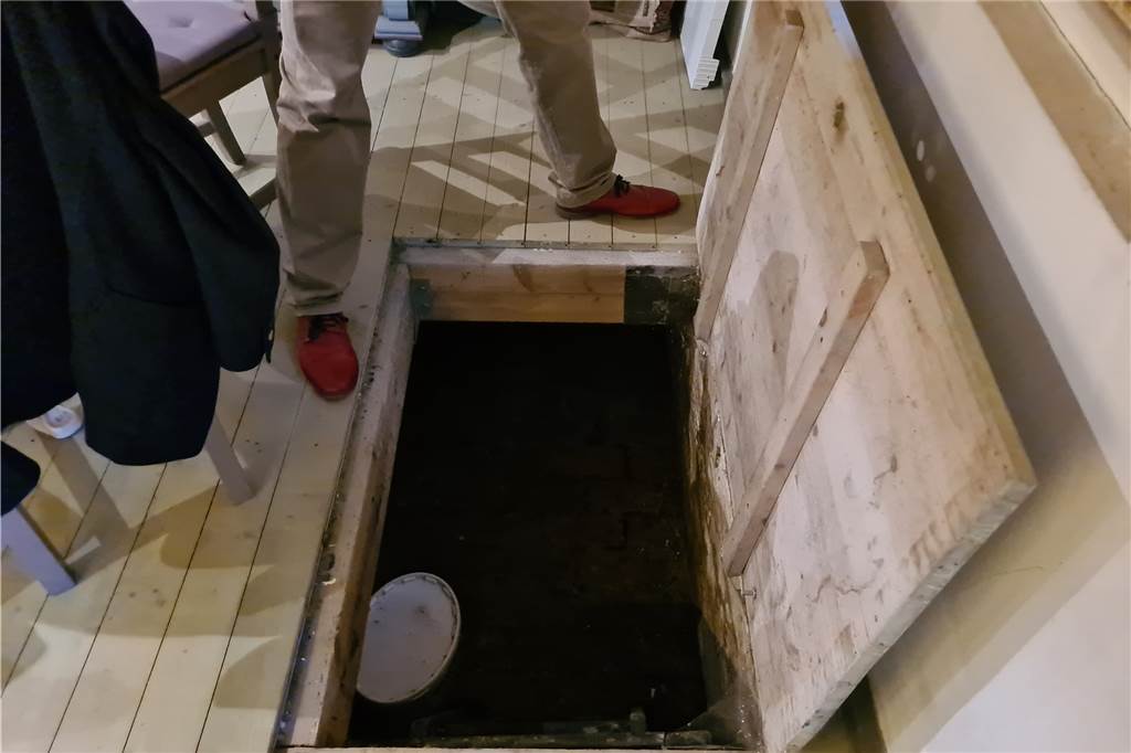 Über eine Klappe im Dielenboden gelangt man in einen Kriechkeller unter der Küche.