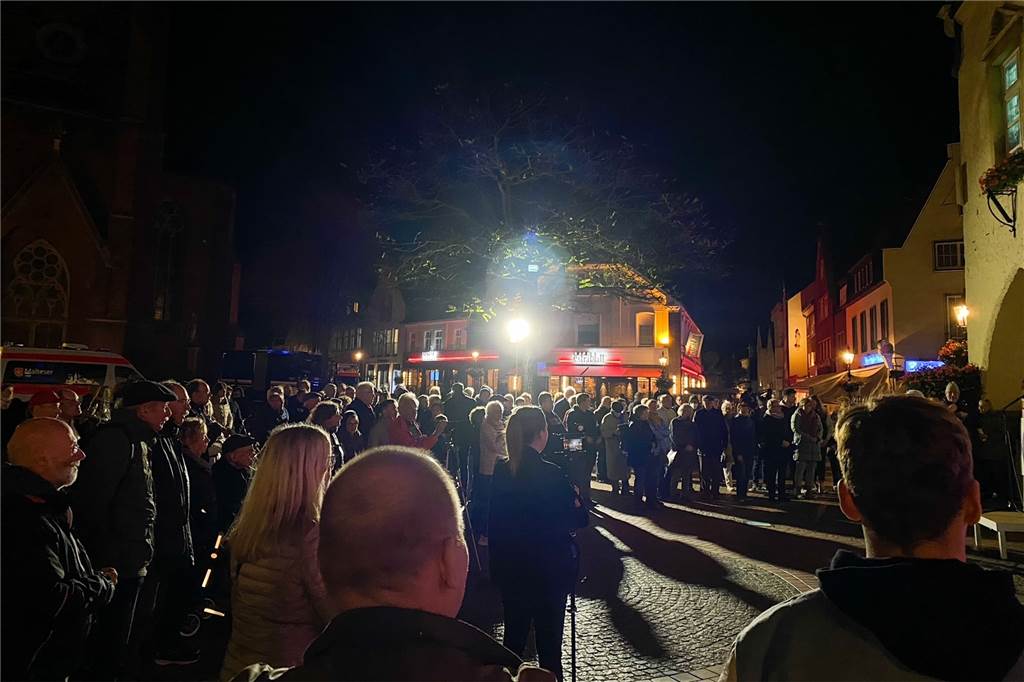 Zahlreiche Besucher gedenken auf dem Marktplatz an Novemberpogrome 1938 Auf dem Foto ist das Publikum vor dem Rednerpult zu sehen und es ist dunkel.