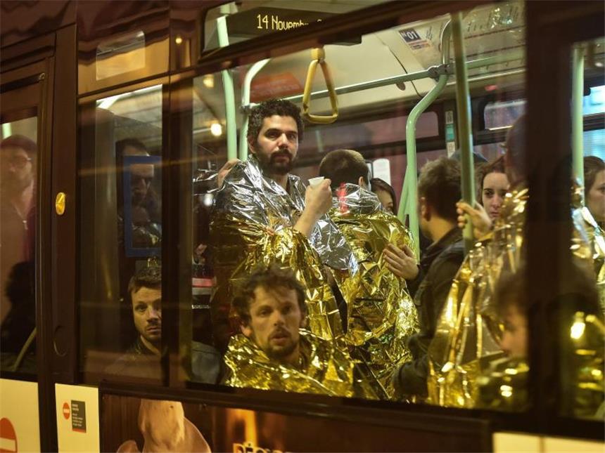 Frankreich steht unter Schock Überlebende werden aus der Umgebung der Pariser Konzerthalle Bataclan weggebracht, wo die Terroristen um sich geschossen hatten. Foto: Christophe Petit Tesson