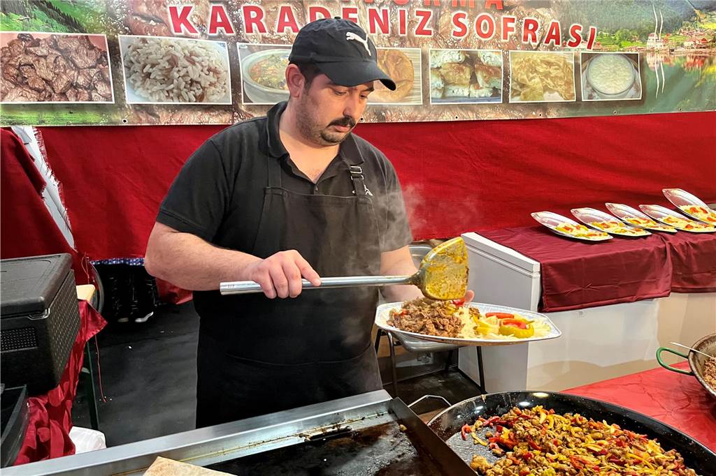Exoten auf dem „Festi Ramazan“ in Dortmund: Wie kommen Speisen aus Afrika und vom Balkan an? Ümit Tabil und sein Team bereiten servieren spezielle Portionen eines türkischen Fleischgerichts zum Fastenbrechen.