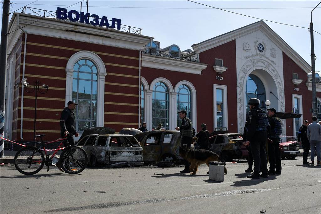 Ein Jahr Krieg in der Ukraine: Diese Orte und Geschehnisse sind besonders in Erinnerung geblieben Ukrainische Soldaten stehen neben beschädigten Autos nach russischem Beschuss des Bahnhofs.