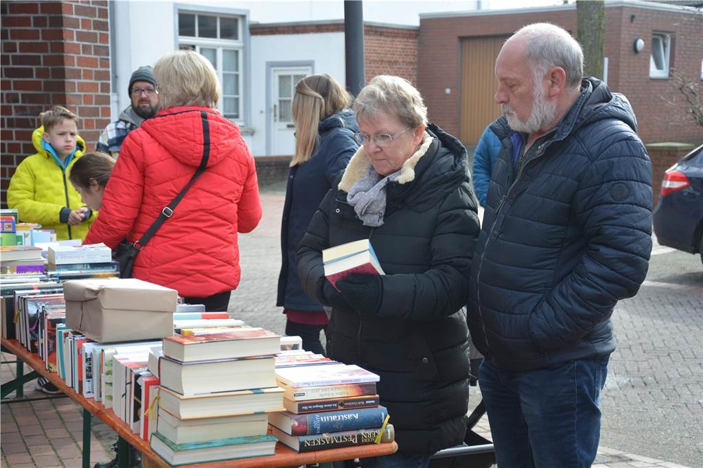 Eine Frau steht vor einer Bank mit Büchern. 