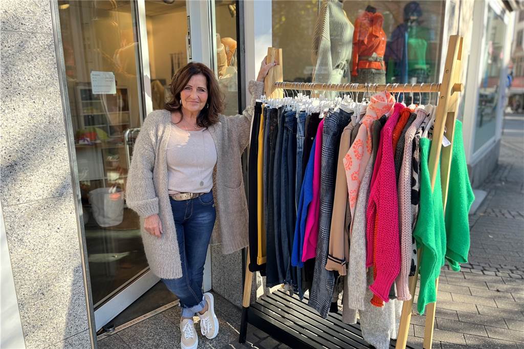 Ulrike Wegscheider steht an der Kleiderstange vor ihrem Modegeschäft "Ella Mode & Accessoires" am Postplatz in Schwerte.