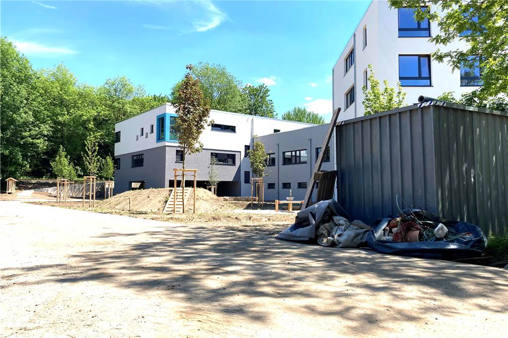 Um das Gebäude herum führt die Zufahrt zu einer kleinen Tiefgarage.