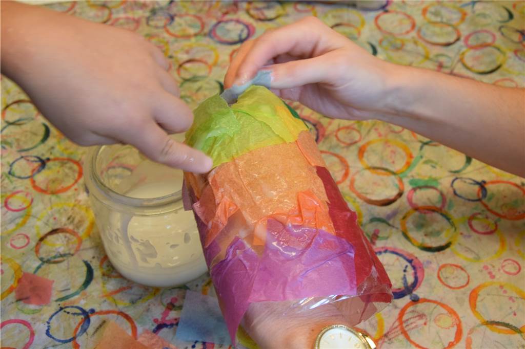 Till (5) zeigt uns, wie man eine bunte Last-Minute-Laterne bastelt Um den Flaschenboden mit Transparentpapier zu bekleben, ist eine zweite Hand hilfreich.