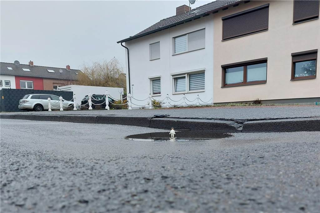 Berthold Borgmeier wünscht sich besseren Zustand der Straßen Ein Playmobilmännchen steht in der Bodenwelle auf dem Söltener Landweg.