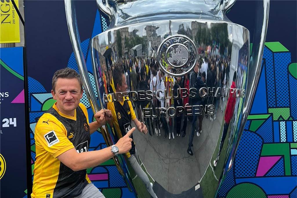 BVB-Fans aus dem Ostvest melden sich aus London Ein Mann im Boruissia-Trikot steht neben einem Pokal.