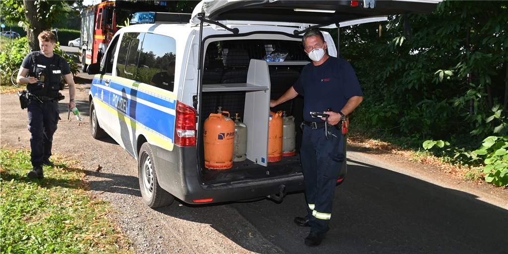 Unbekannte legen Gasflaschen auf die Gleise in Dorsten - Polizei sucht Zeugen Ein Feuerwehrmann steht vor dem Polizeiwagen, in dessen Kofferraum sich die vier Gasflaschen befinden.