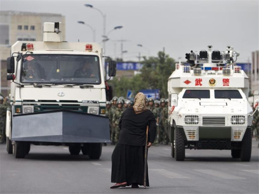 31 Tote bei Anschlag in Chinas Unruheregion Xinjiang Ungleiche Kräfteverhältnisse: Eine Uigurin sieht sich Panzerfahrzeugen gegenüber. Foto: Diego Azubel/Archiv
