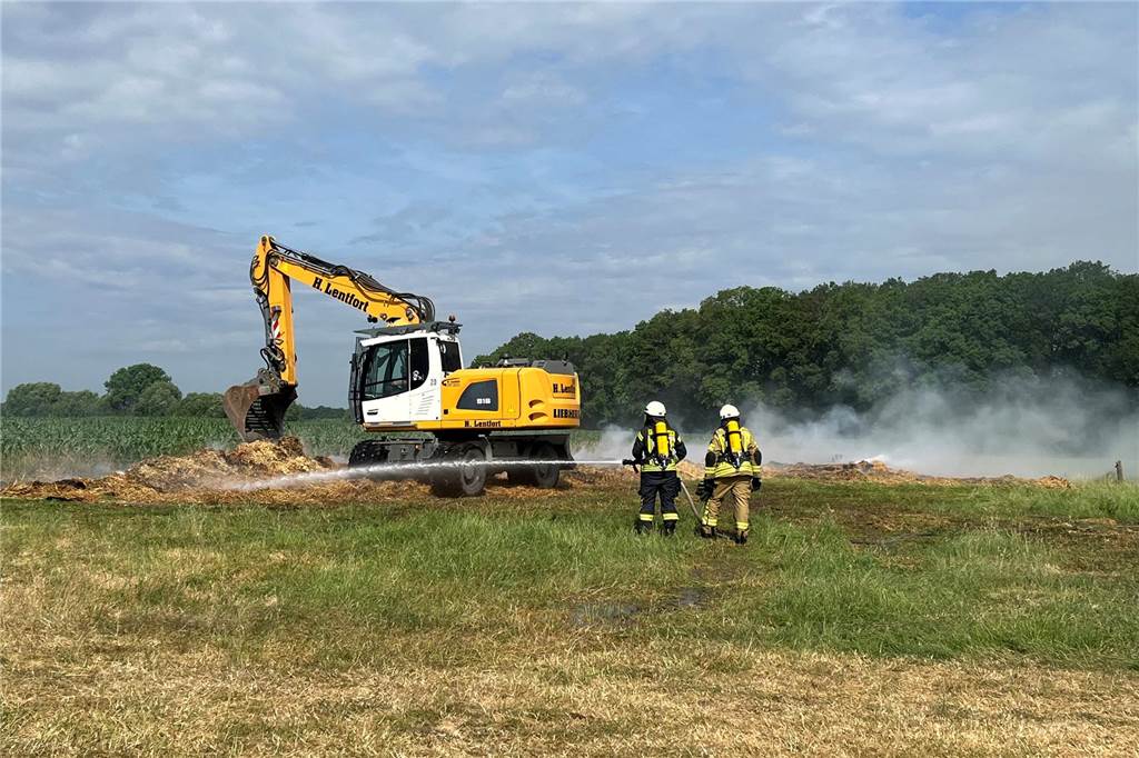 Halle in Crosewick komplett ausgebrannt: Großeinsatz für Vredener Feuerwehr Unter Atemschutz löschen die Kameraden das Stroh auf der Weide ab.
