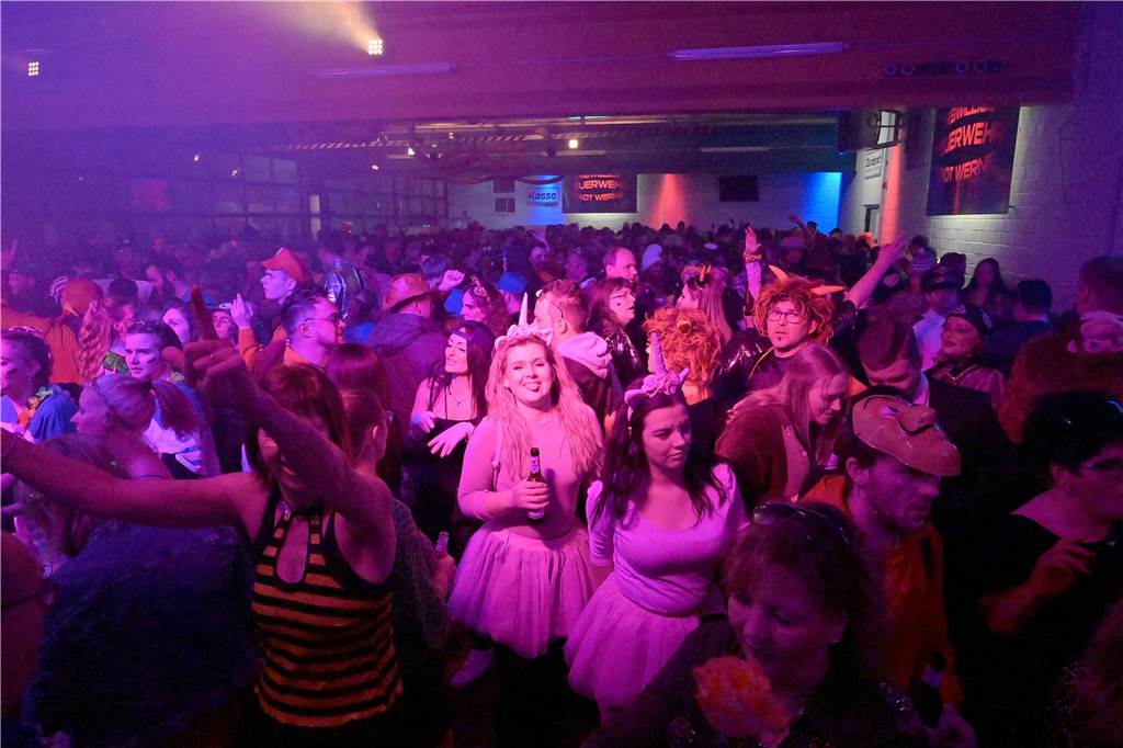 Eine kostümierte Menge bei der Feuerwehr in Werne feiert Karneval.