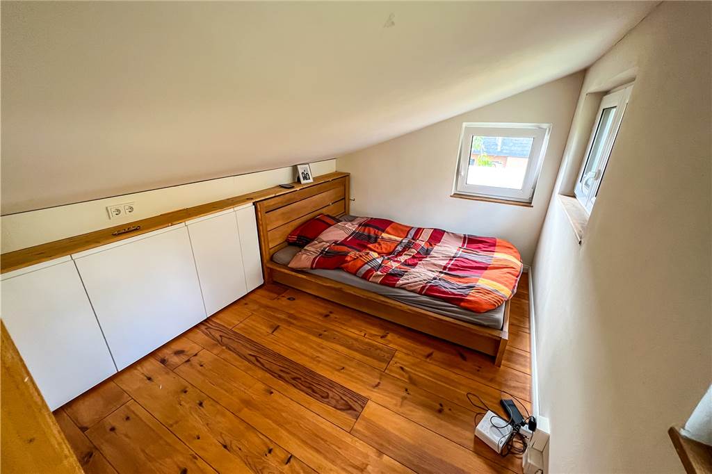 Wohnen auf 28 Quadratmetern – im eigenen Tiny House Ein kleines Schlafzimmer mit Dachschräge.
