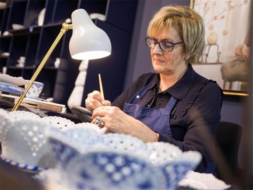 Neuer Fokus bei Küchen- und Essgeschirr Unternehmen wie Royal Copenhagen besinnen sich auf ihre Traditionen und Handwerkskunst. Auf der Konsumgütermesse Ambiente verzierte Porzellan-Malerin Mai-Lis Nilsen Tassen eigenhändig. Foto: