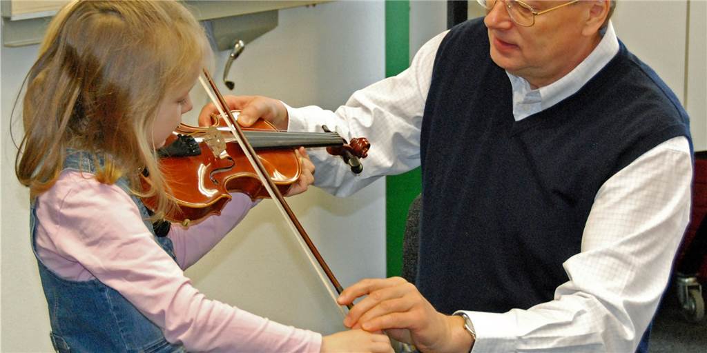 Unterricht an der Musikschule Dorsten wird deutlich teurer Lehrer erklärt Kind das Geigespielen