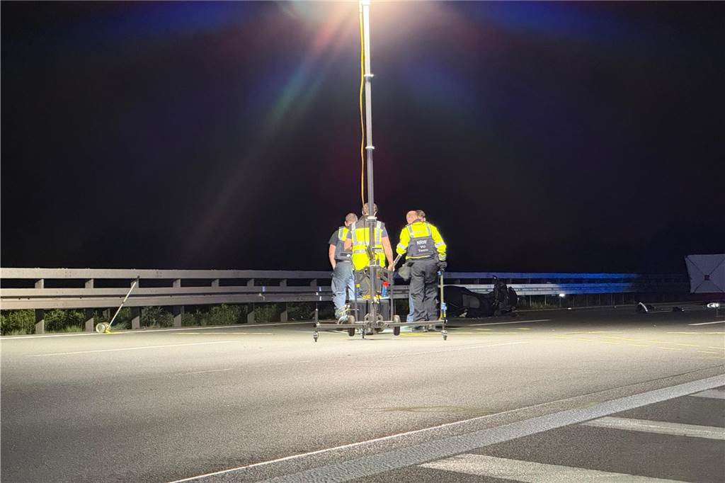Polizeibeamte im Scheinwerferlicht auf der dunklen Autobahn