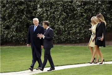 US-Präsident Trump und seine Frau gehen mit Emmanuel Macron und seiner Frau über den Südrasen des Weißen Hauses. Foto: Evan Vucci, AP