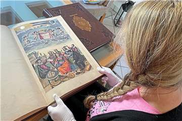 Ute K. präsentiert unserer Redaktion zwei der nachgeahmten historischen Bücher, die ihre Bekannte für viel Geld gekauft hat. Vor ihr aufgeschlagen liegt das Faksimile der „Harmonia Macrocosmica“, daneben der „Atlas Gerardus Mercator“. 