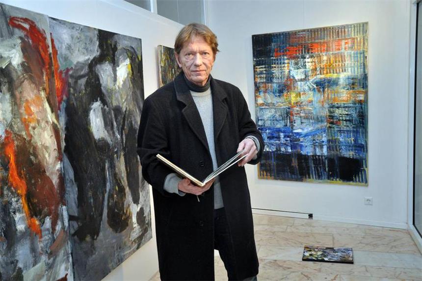 Uwe Gegenmantel ist Träger des Kulturpreises 2013 Uwe Gegenmantel mit einem Malbuch in der Hand vor den Ölbildern "Malpalette" (l.) und "Szene". Der Maler ist mit dem Kulturpreis der Stadt Lünen 2013 ausgezeichnet worden.