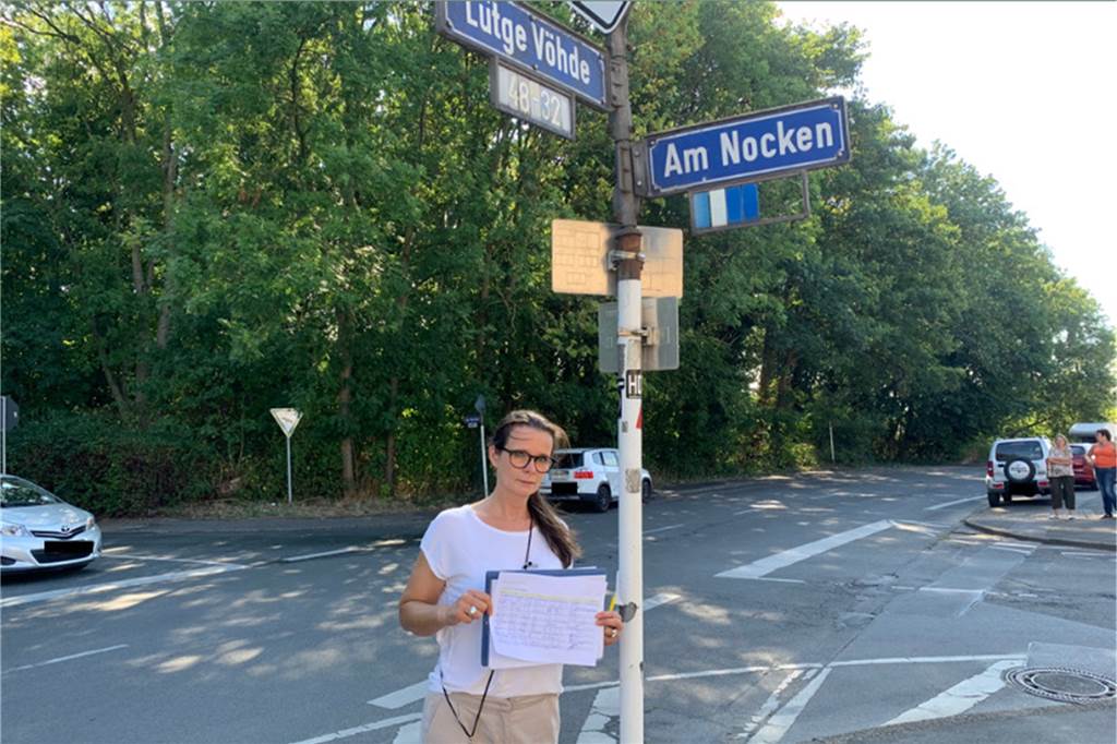 Anwohner im Dortmunder Westen kämpfen für Tempo 30: „Der letzte Versuch" Vanessa Wiemers steht vor den Straßenschildern Lütge Vöhde/Am Nocken. Sie hält eine Liste mit Unterschriften für die Forderung nach Tempo 30 hoch.