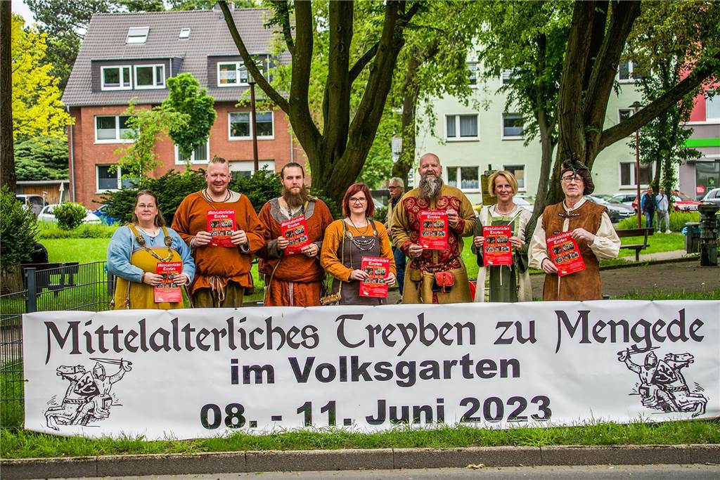 „Mittelalterliches Treyben zu Mengede“: Größeres Angebot für Kinder Teilnehmer und Veranstalter hinter einem Werbebanner für das "Mittelalterliche Treyben" am Mengeder Amtshauspark.