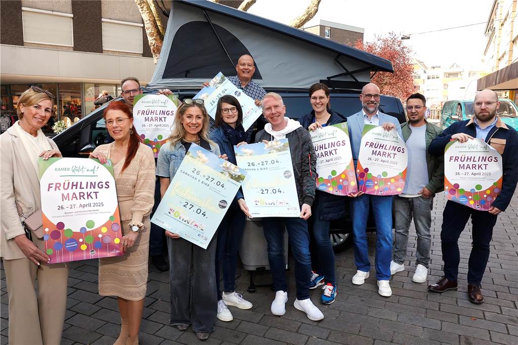 Frühlingsmärkte und verkaufsoffener Sonntag: Tipps für das Wochenende Veranstalter und Teilnehmer des Frühlingsmarktes 2025 in Kamen stehen mit Plakaten für den Frühlingsmarkt in der Fußgängerzone