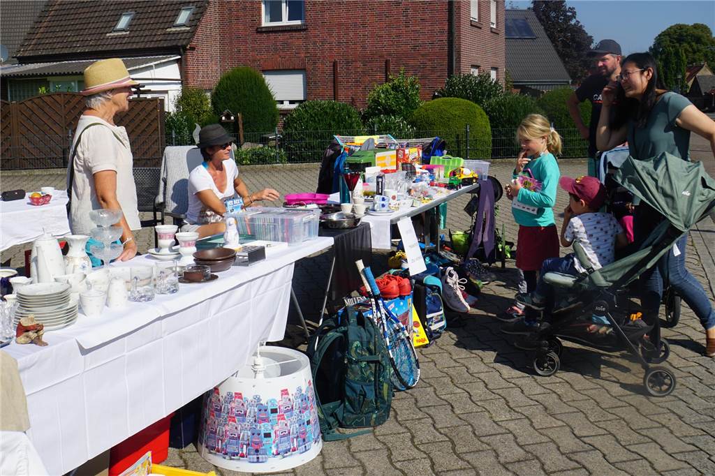 Dorftrödelmarkt lockt Schnäppchenjäger - auch Delfine spielen eine Rolle Verkäufer und Käufer verhandeln an einem Stand.