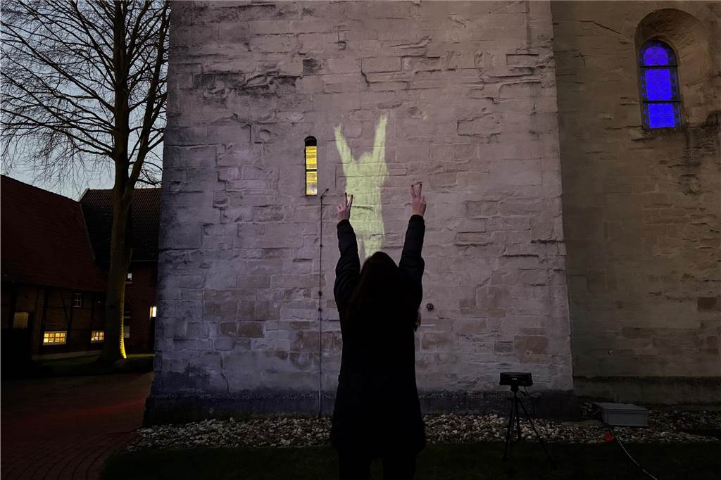 Kunstinstallation begeistert beim Asbecker Lichterglanz Ein Mensch vor einer Kirchenmauer