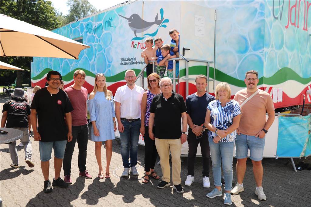 120 Kinder werden sich im Schwimmcontainer ans Wasser gewöhnen Menschen vor einem bunten Container