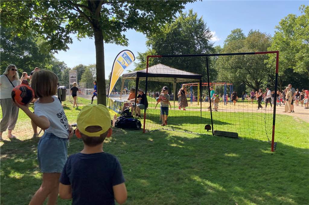 Zu sehen sind spielende Kinder, deren Eltern und weitere Besucher, die zur Eröffnung neuen Superspielplatz in Castrop-Rauxel gekommen sind.