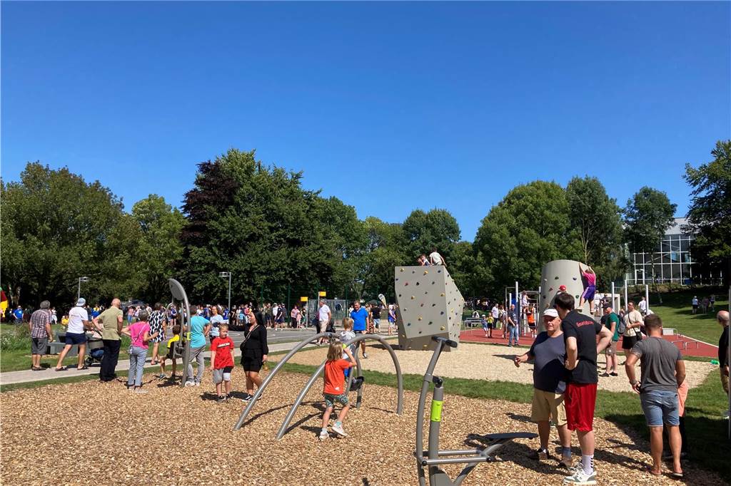 Zu sehen sind spielende Kinder, deren Eltern und weitere Besucher, die zur Eröffnung neuen Superspielplatz in Castrop-Rauxel gekommen sind.