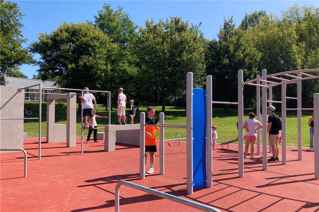 Zu sehen sind spielende Kinder, deren Eltern und weitere Besucher, die zur Eröffnung neuen Superspielplatz in Castrop-Rauxel gekommen sind.